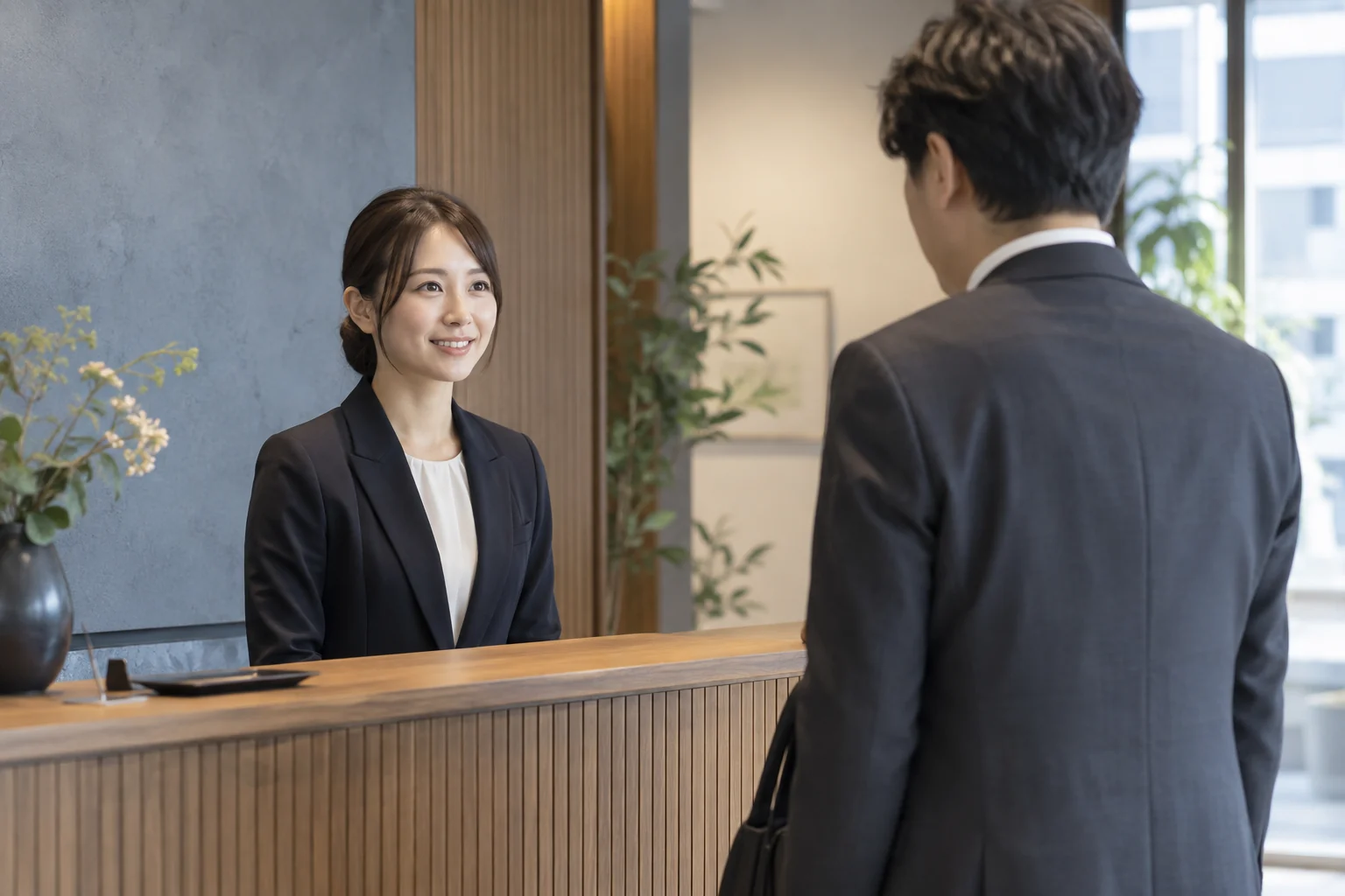 来訪者を受付でお迎えするスタッフ